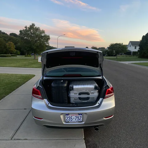 Packed suitcases in a car boot at dawn