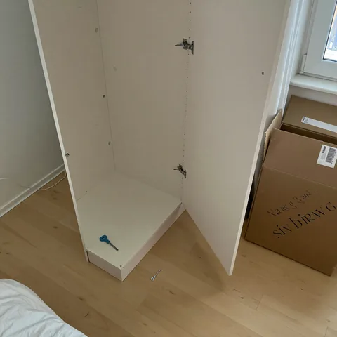 Half-assembled flat-pack wardrobe with tools